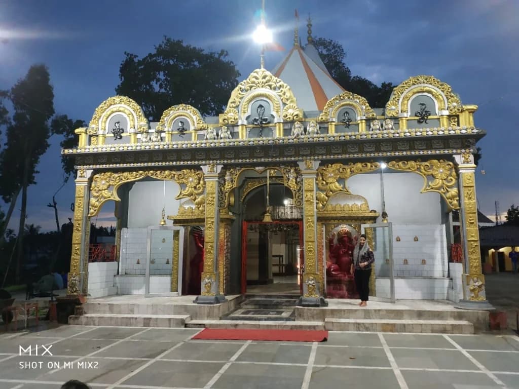 Illuminated ornate golden entrance facade of Mahabhairab Temple at dusk
