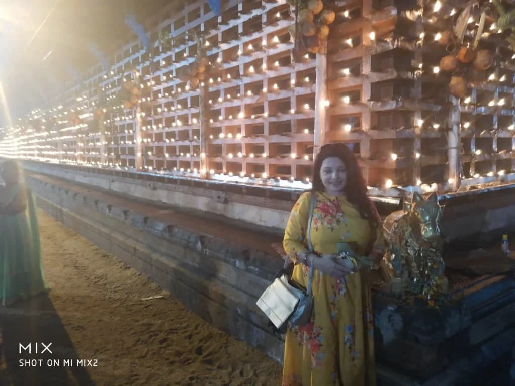 Standing in front of the illuminated temple lamps