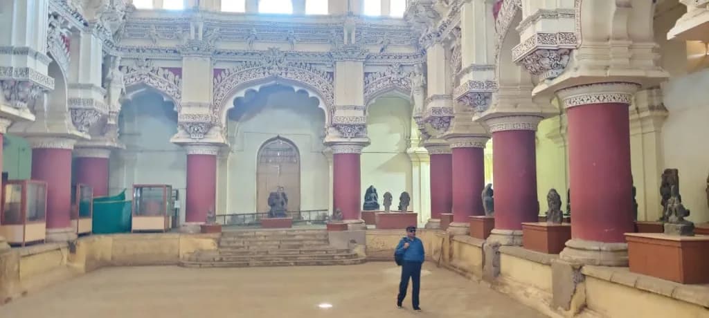 Historic inner hall with red pillars and Dravidian-Islamic arches