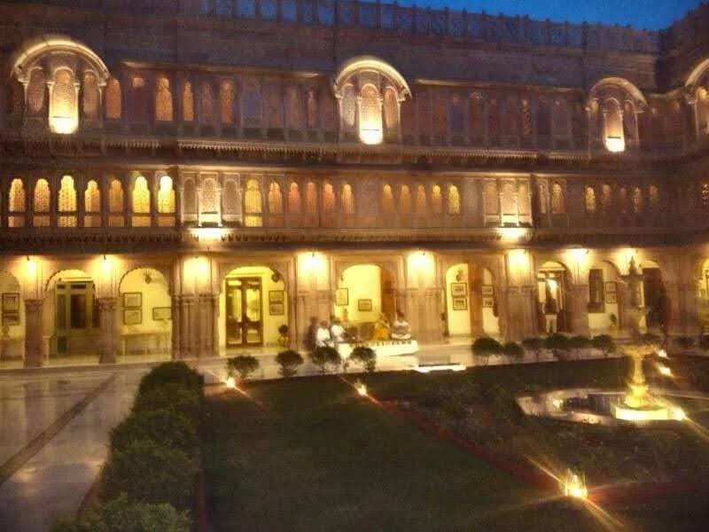 Illuminated golden sandstone facade of Suryagarh palace at night in Jaisalmer
