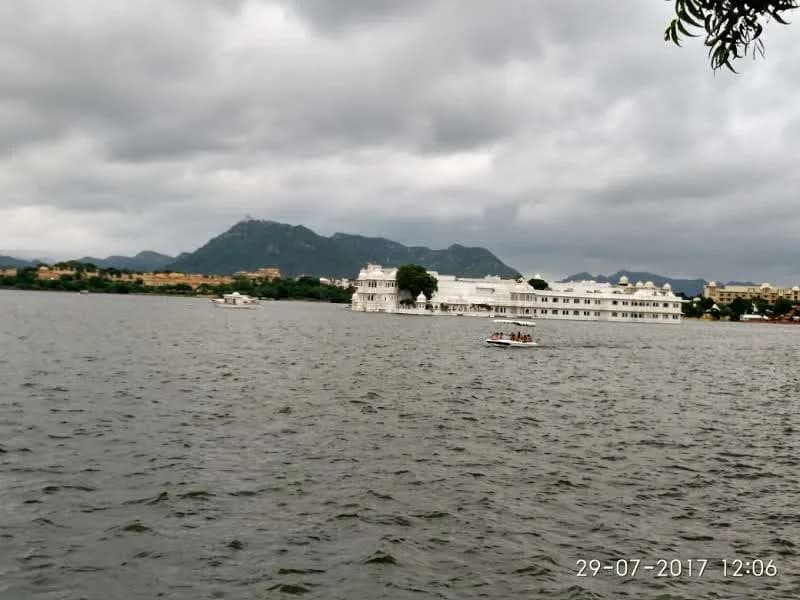 Panoramic view from Jag Mandir Palace floating on Lake Pichola under dramatic Aravalli mountain ranges
