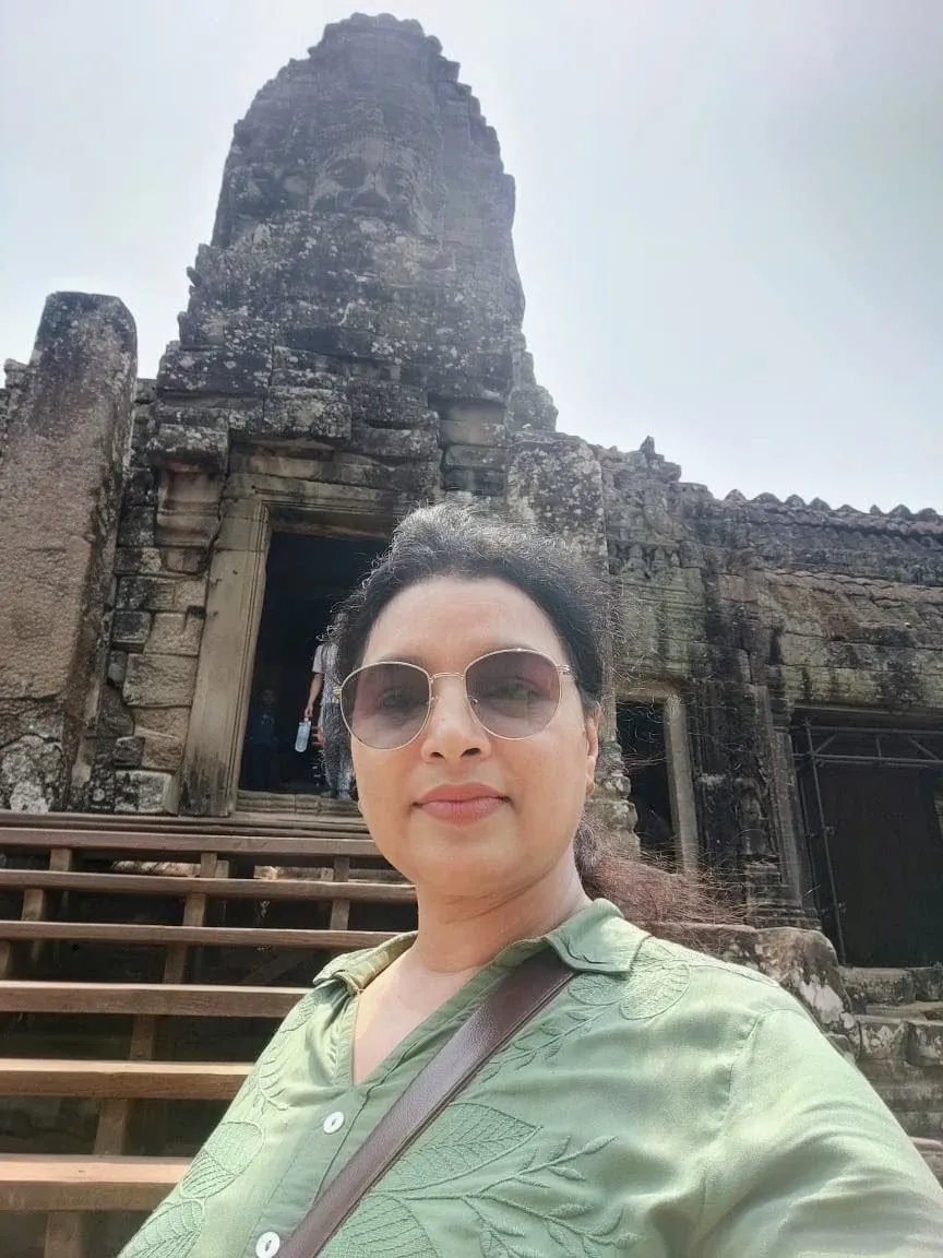 Woman taking a selfie in front of the Bayon temple structure