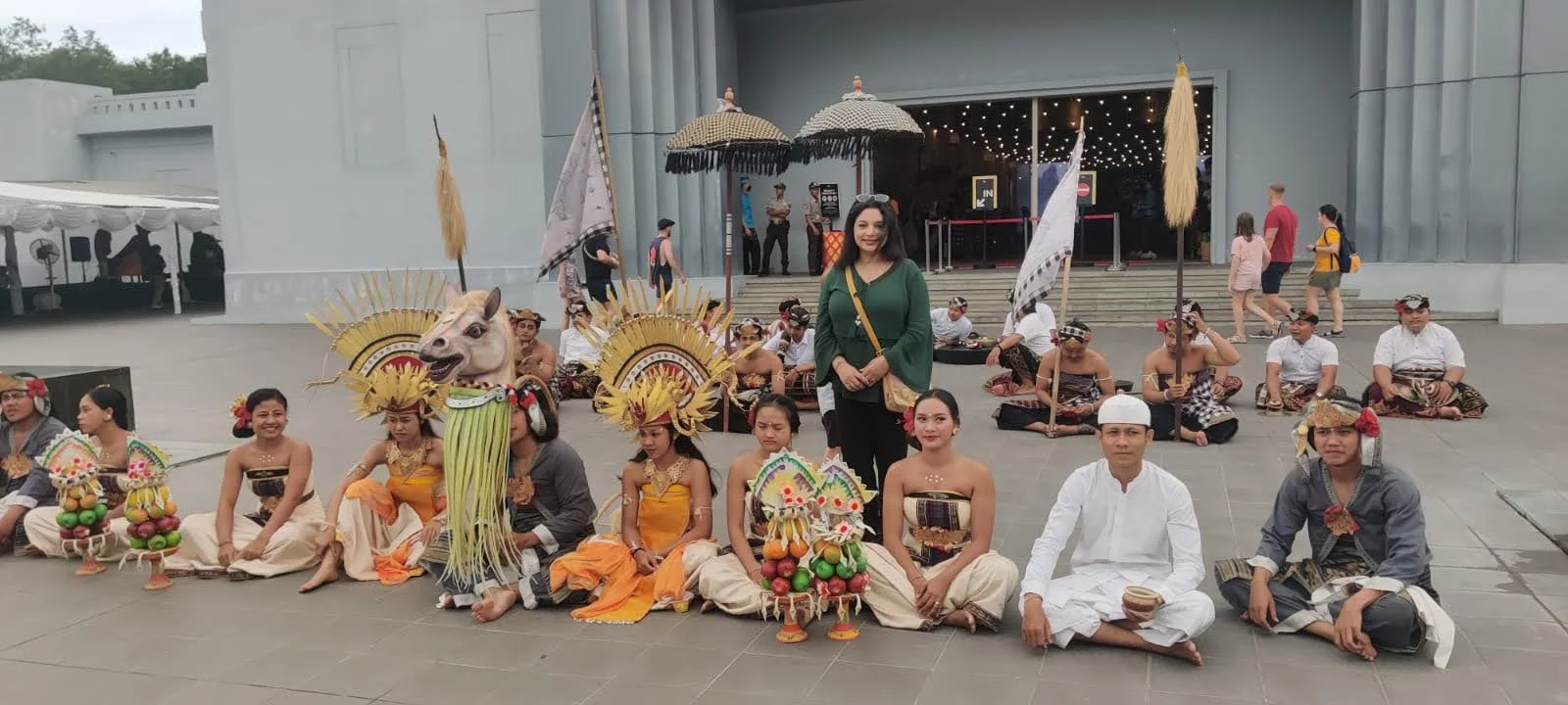 Archana gathered with the seated Balinese ceremonial dance troupe in gold headdresses and umbrellas