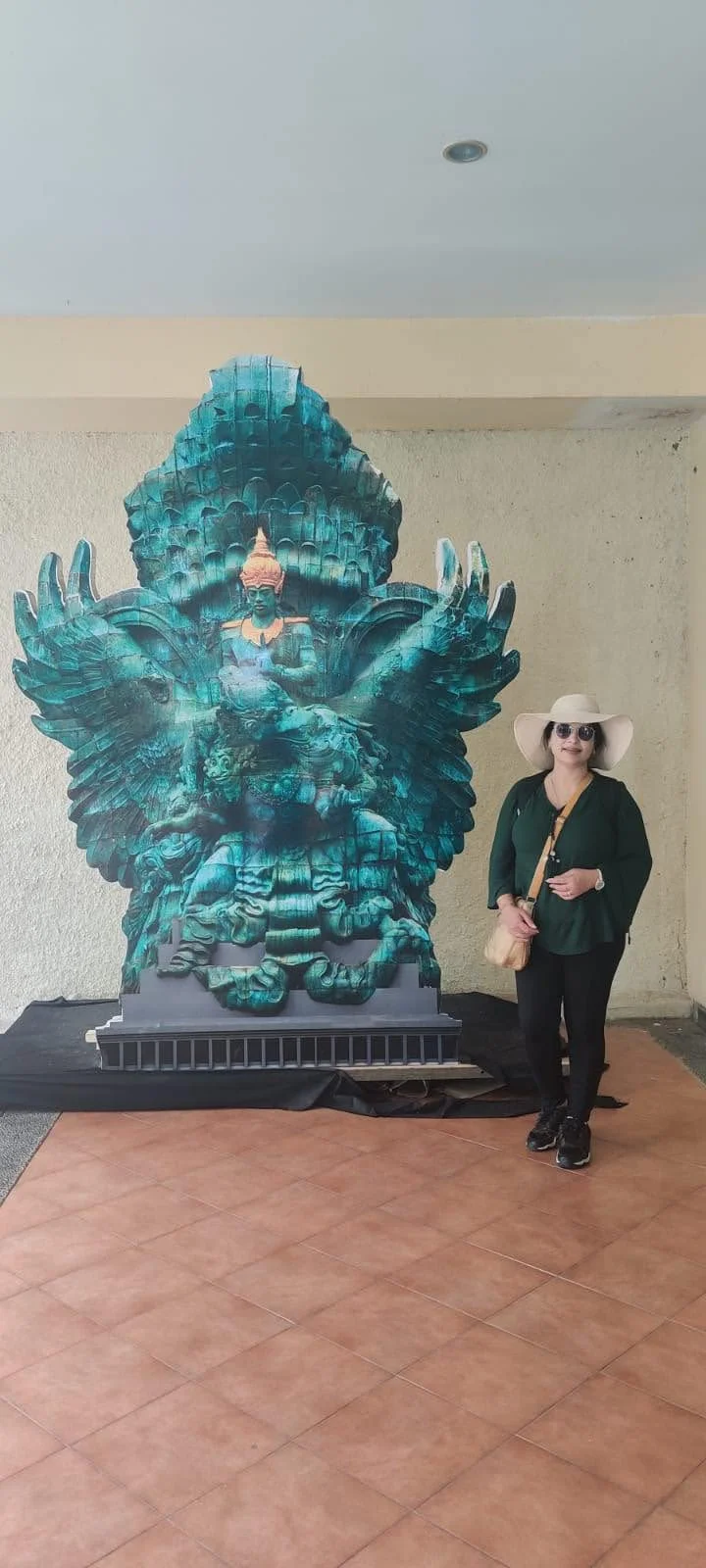 Archana standing beside the detailed sculptured model of Garuda Wisnu statue