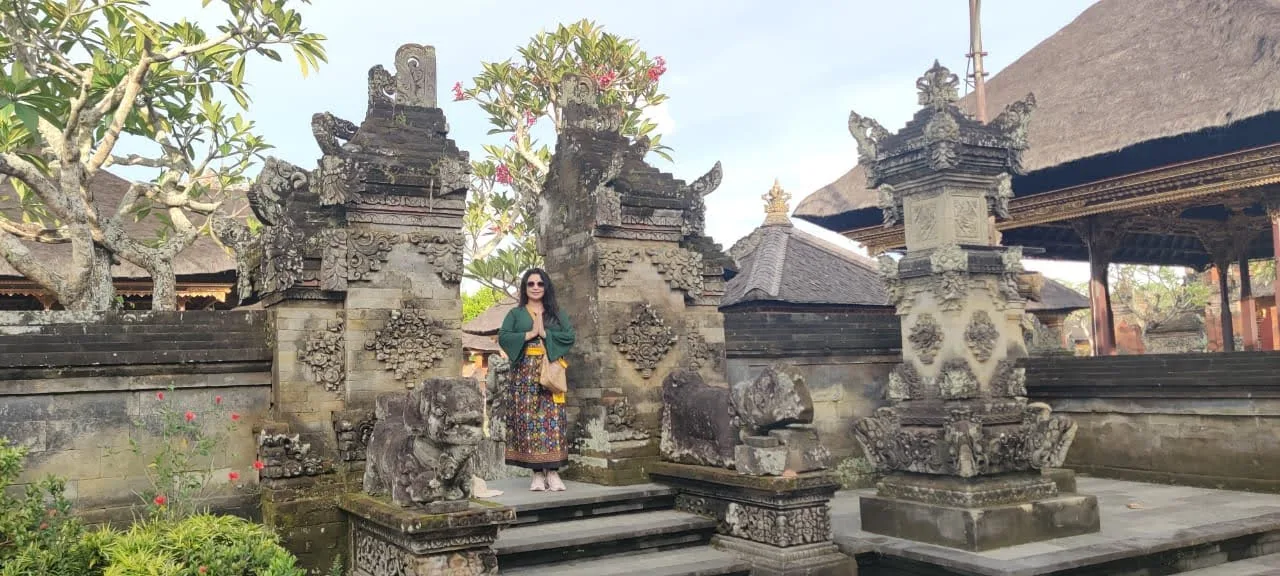 Traveler passing through the monumental candi bentar split gateway of Batuan Temple in Bali