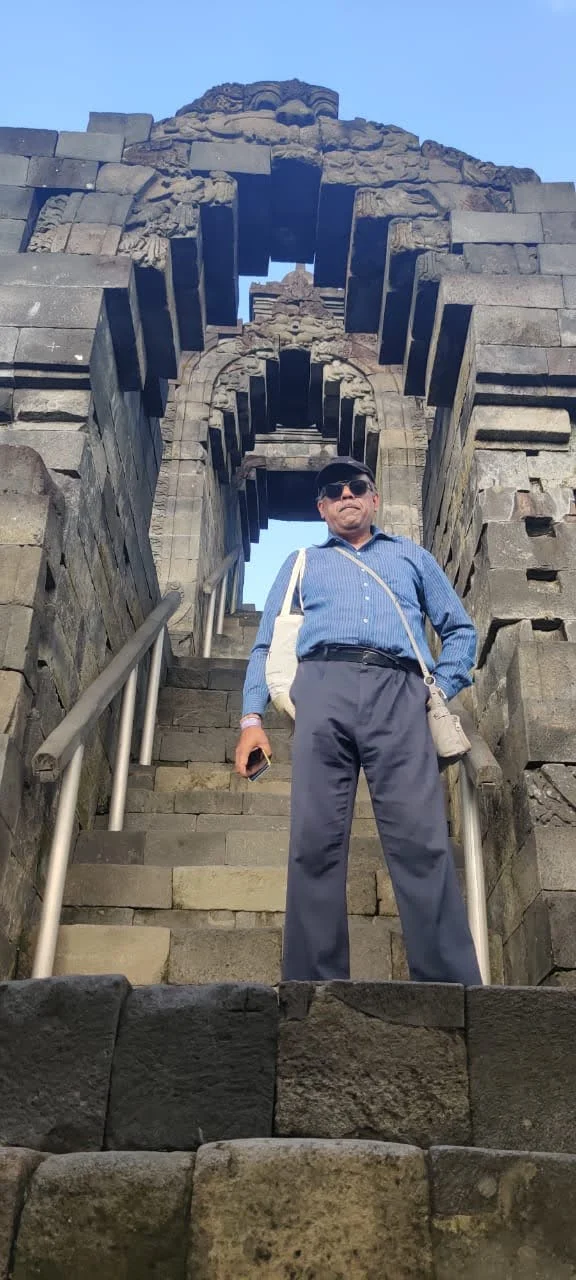 Traveler ascending the steep stone steps through an arched Kala gateway framed by stupas