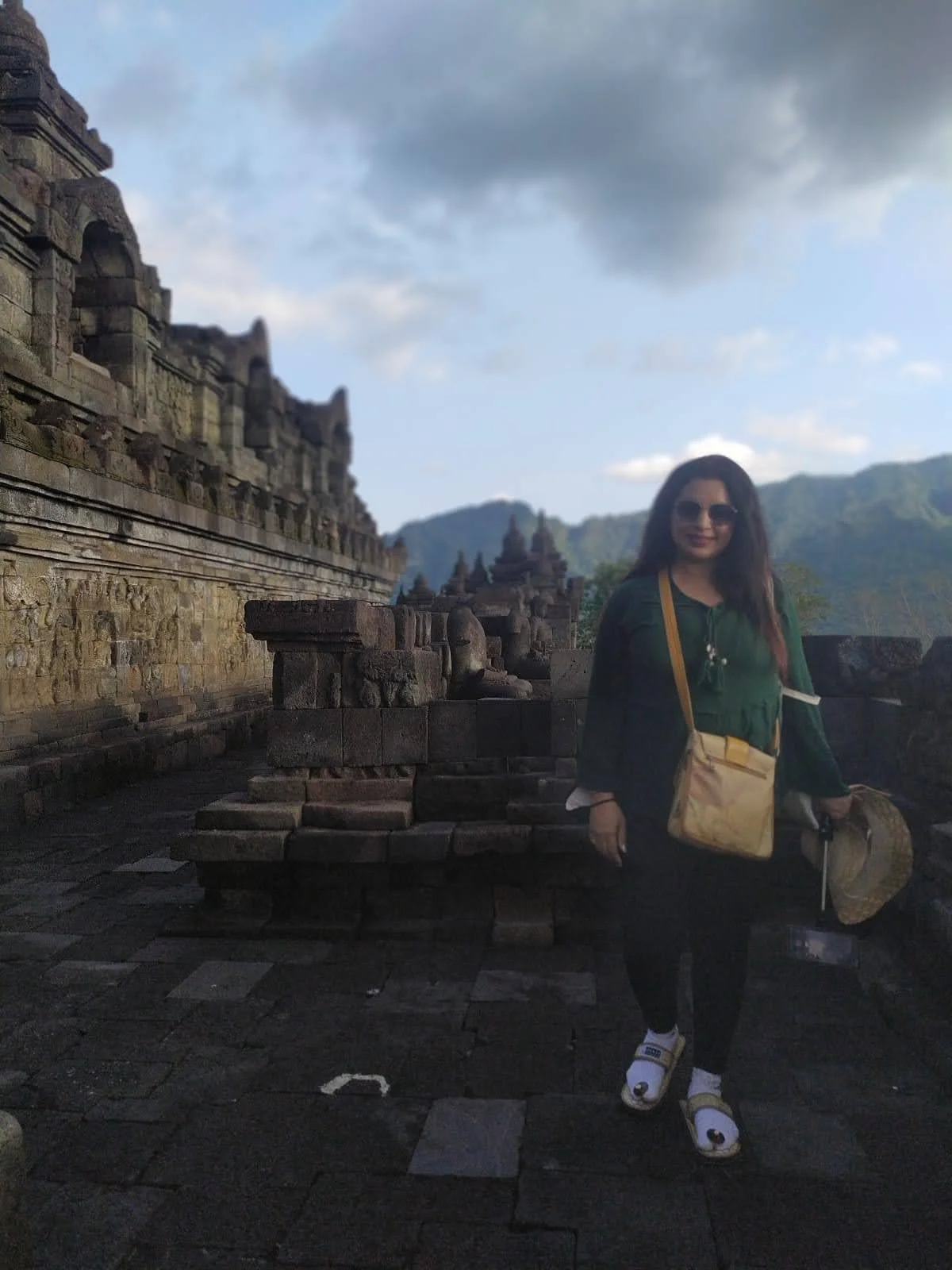 Traveler walking through the narrow open-air relief gallery wearing soft protective upanat sandals