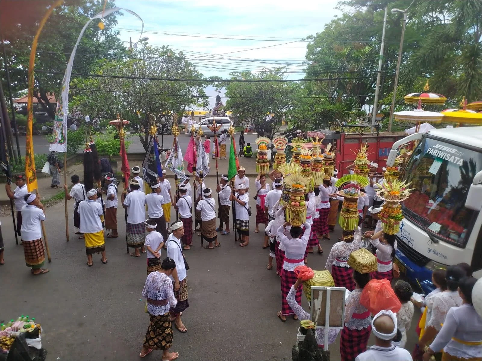 High-angle view of Balinese women balancing monumental gebogan offering towers on their heads in Odalan procession