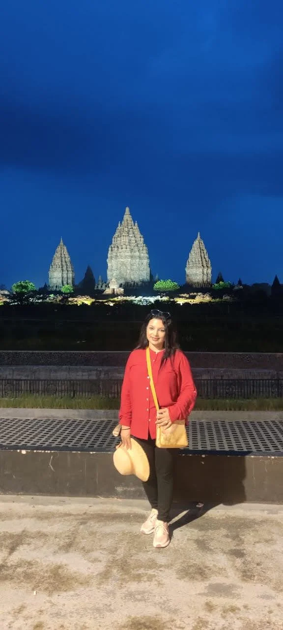 The three illuminated Trimurti temples of Prambanan glowing in the twilight sky