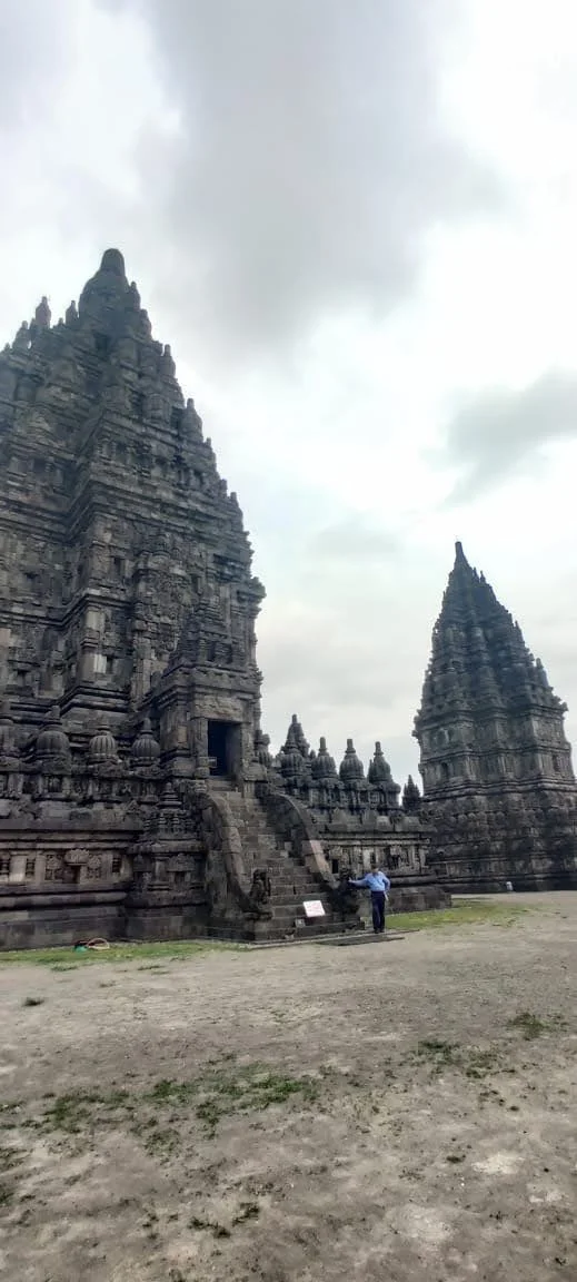 Monumental stone staircase ascending into the central Shiva Mahadeva temple with traveler at the base