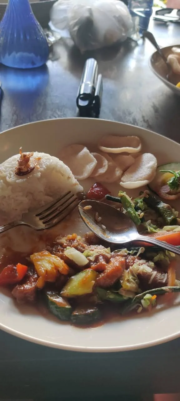 An authentic Balinese dinner plate with fragrant spiced rice, skewered meats, and vibrant sambal accompaniments in Nusa Dua