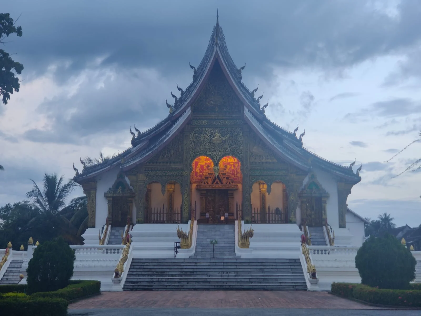 Haw Pha Bang royal temple illuminated in gold in the evening at the Royal Palace Museum complex in Luang Prabang