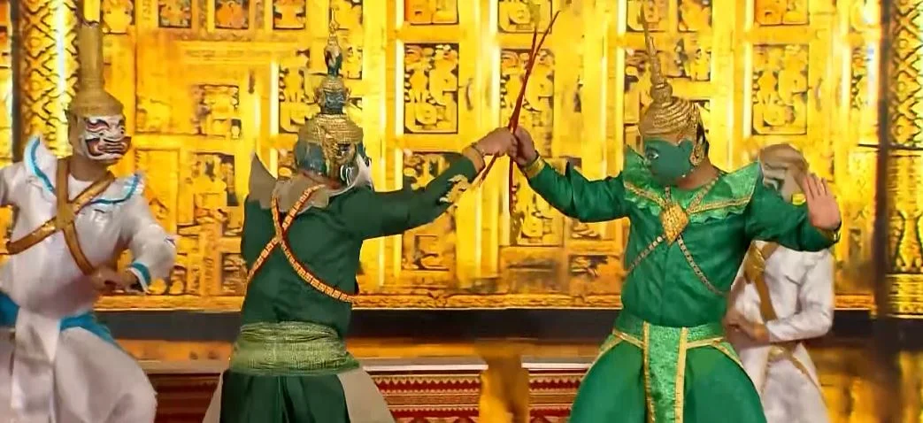Dramatic live stage performance of Phra Lak Phra Lam at the Royal Theatre with classical Lao dancers dressed as Phra Lam, Phra Lak, and the demon king Totsakan in ornate gilded masks and costumes