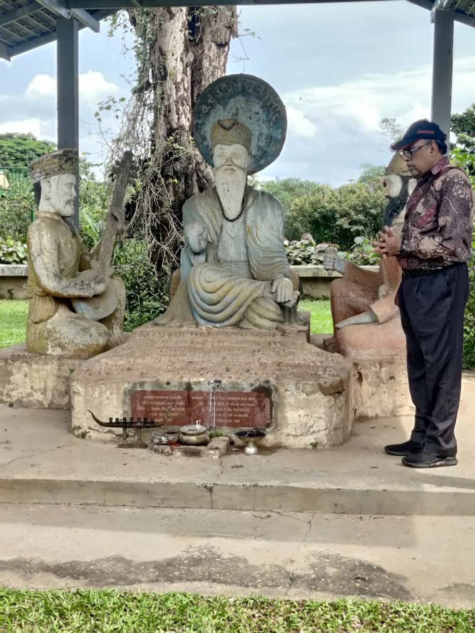 Traveler standing beside a unique dedicated shrine honoring Guru Nanak Dev Ji within the syncretic park