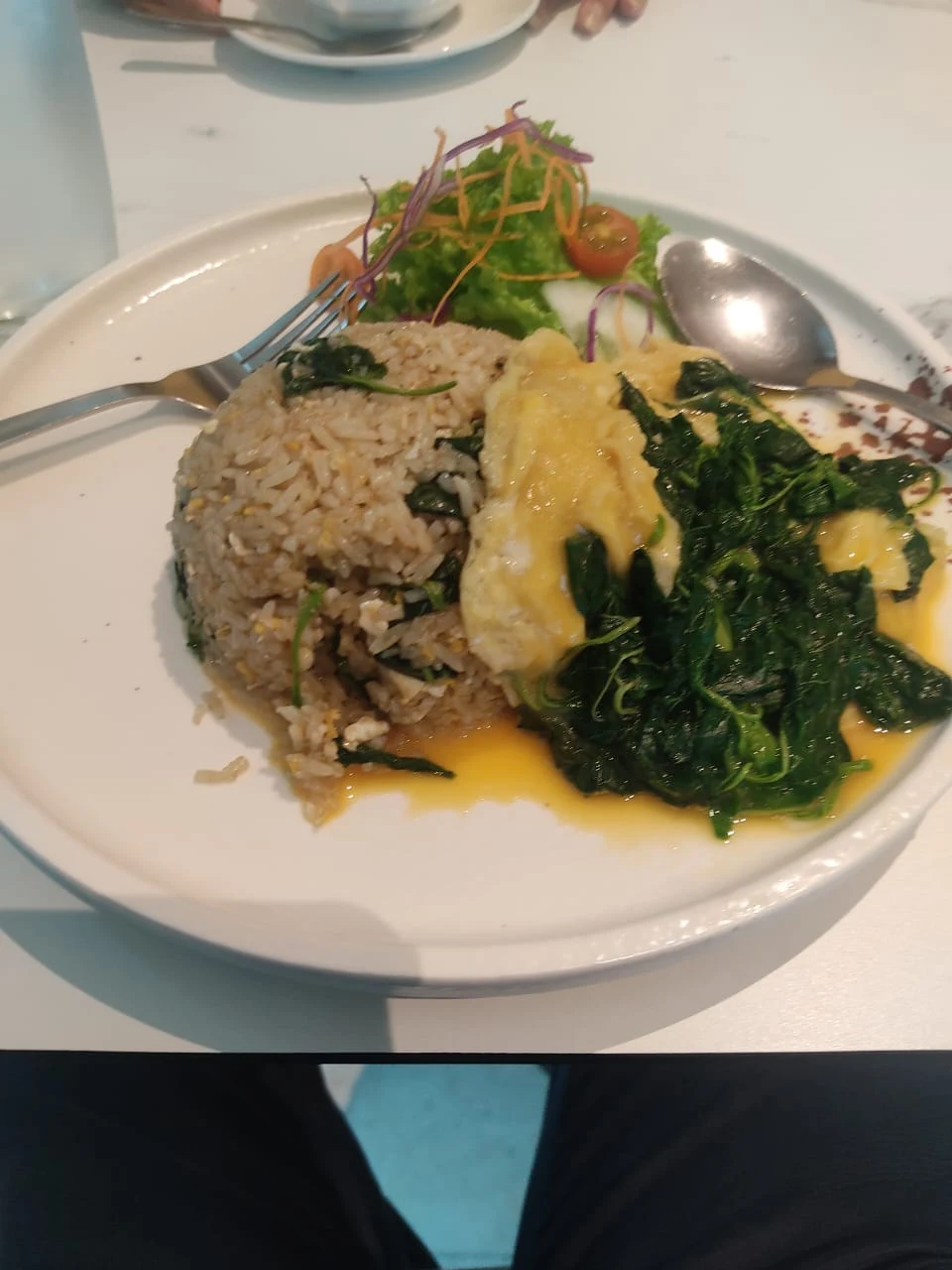 A flavorful serving of traditional Malaysian Nasi Goreng Kampung with fried egg and leafy greens