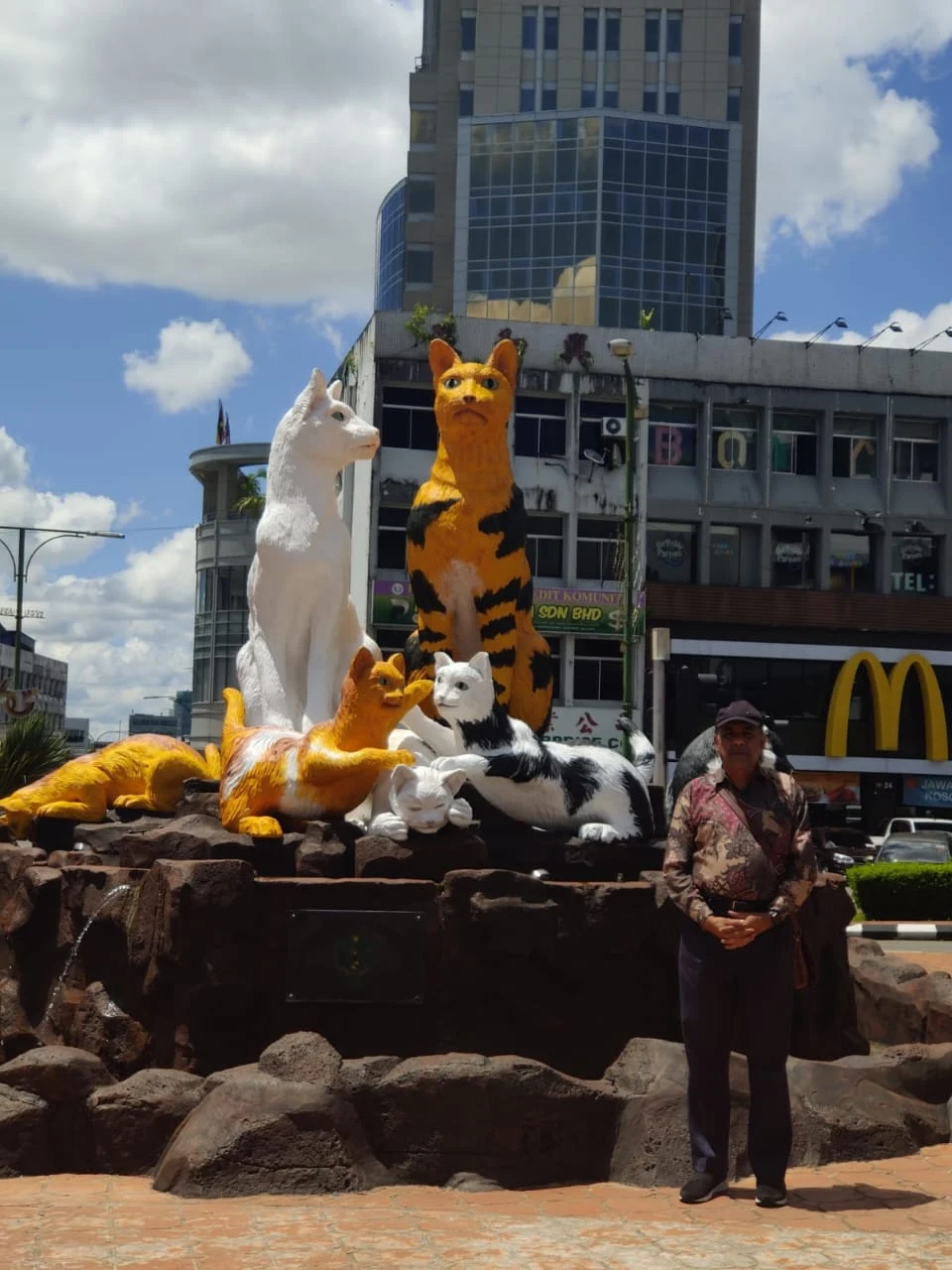 Male traveler posing next to the famous Kuching Cat Statue monument in Sarawak