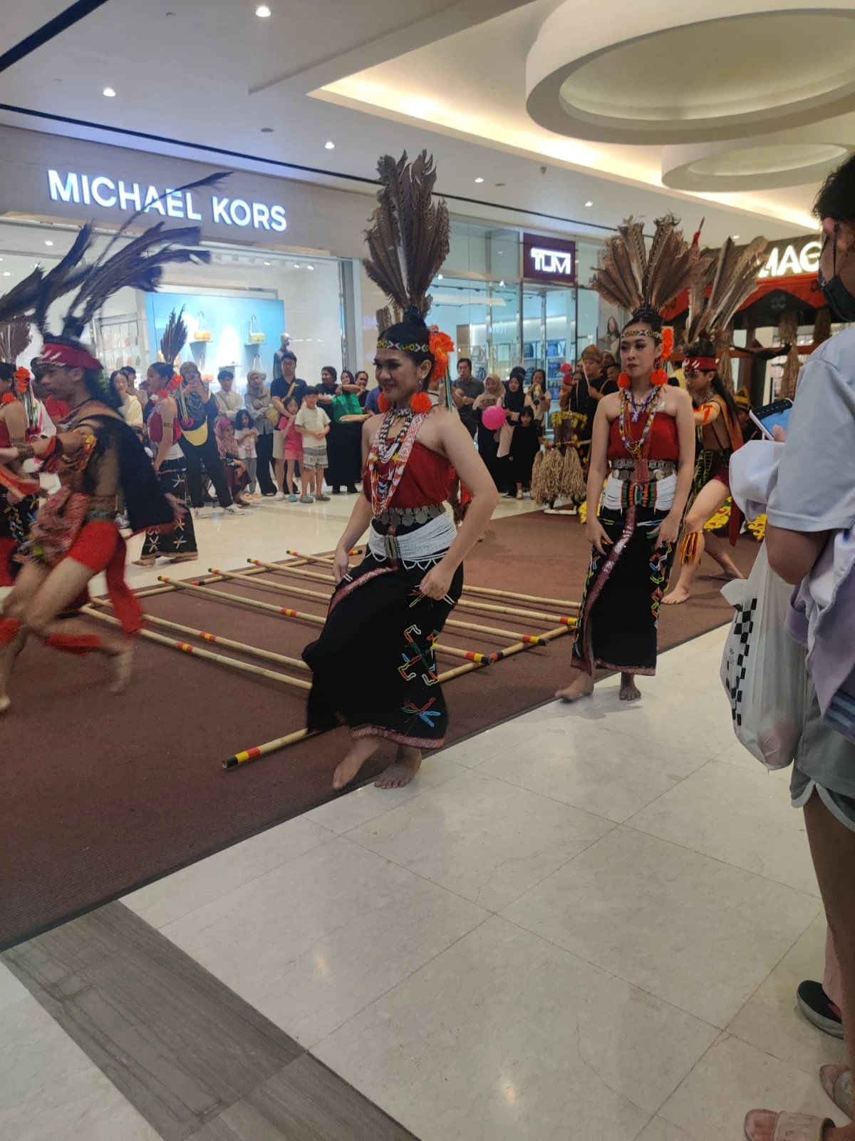 Dynamic performance of the Murut Magunatip bamboo pole dance with dancers leaping gracefully between rhythmic clapping bamboo poles