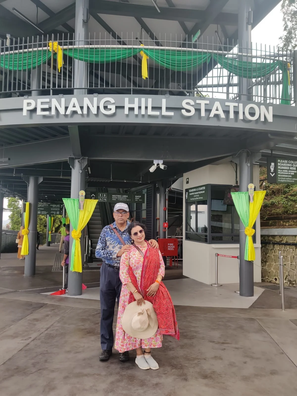 Couple travelers standing before the entrance of Penang Hill Station funicular railway