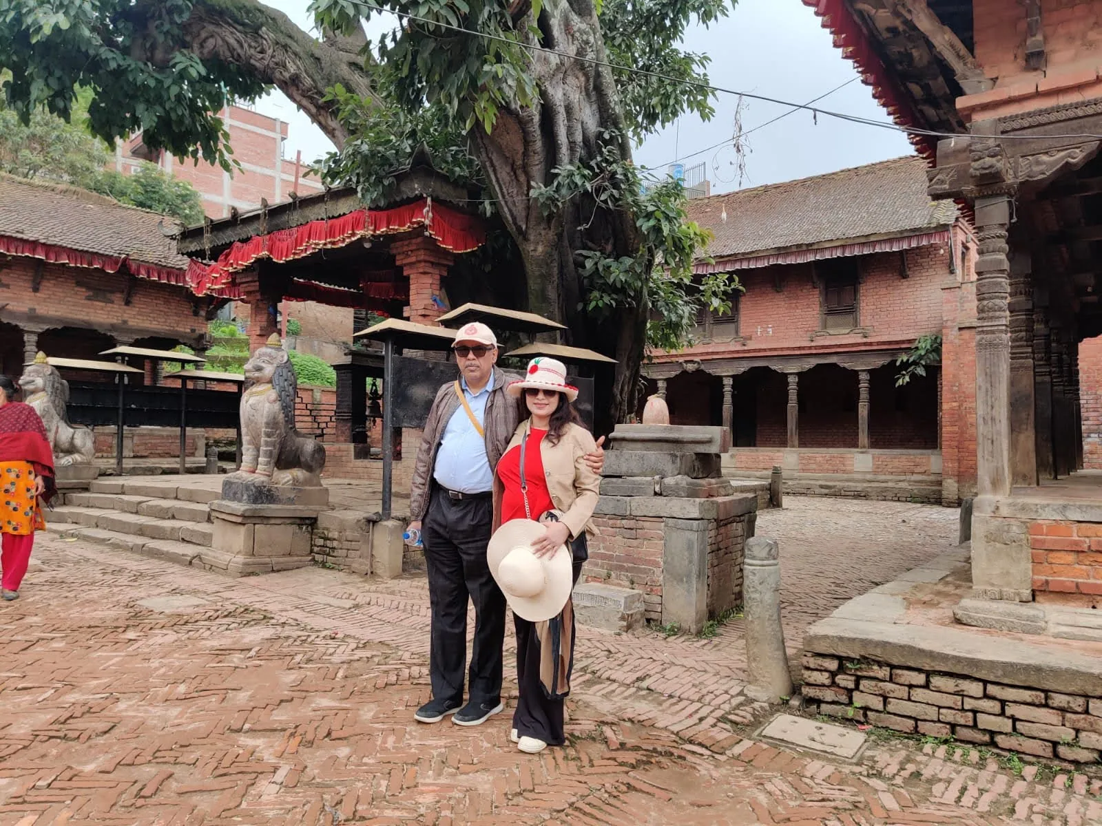 Historic brick courtyard with sacred Peepal tree and prayer shrines in Bhaktapur