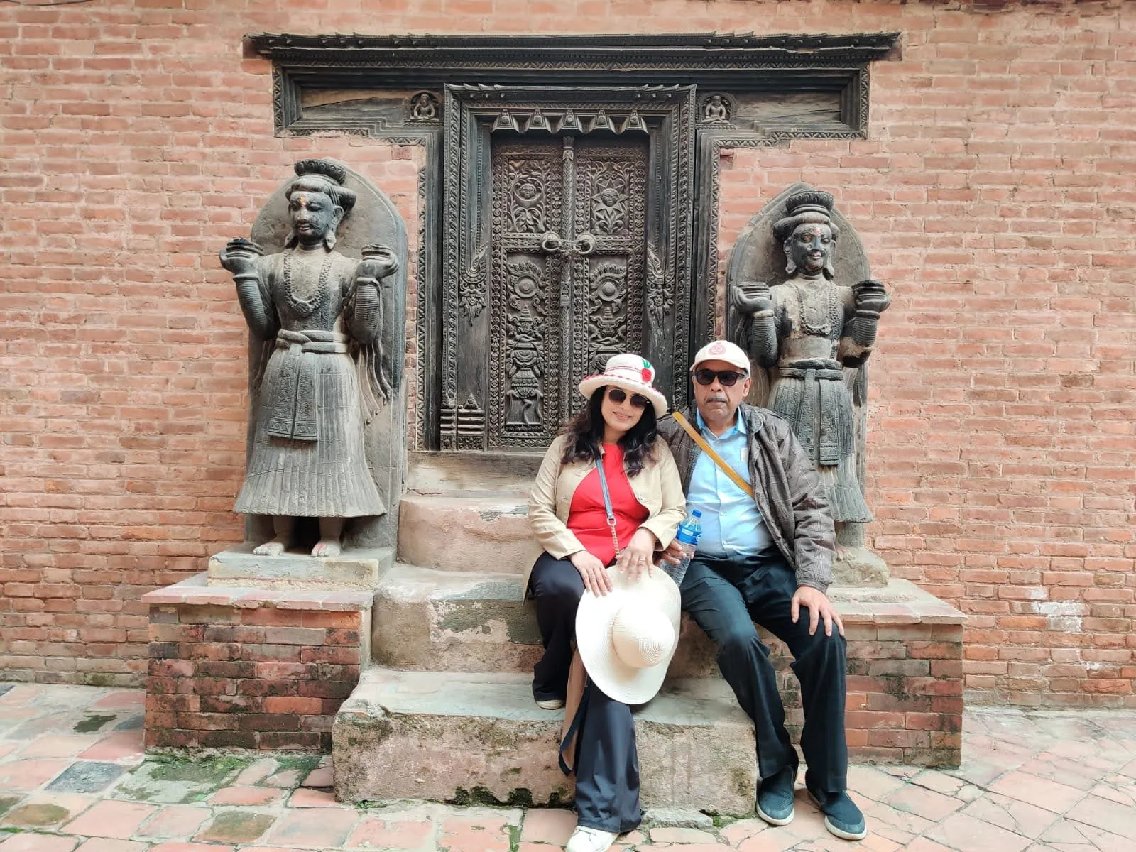 Carved wooden gateway and stone dvarapala guardians at Taleju Temple