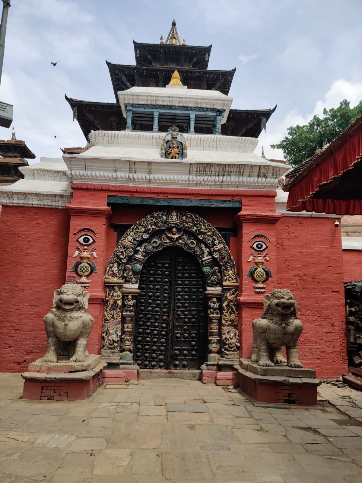 Hanuman Dhoka Palace Golden Gate with guardian lions, painted eyes, and Taleju pagoda backdrop
