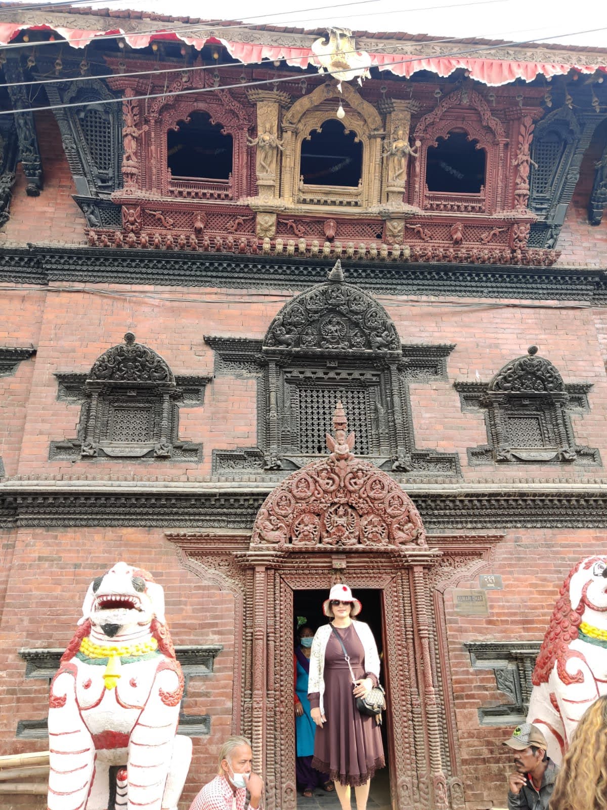 Kumari Ghar palace facade in Kathmandu Durbar Square with painted stone lions and intricately carved wooden windows