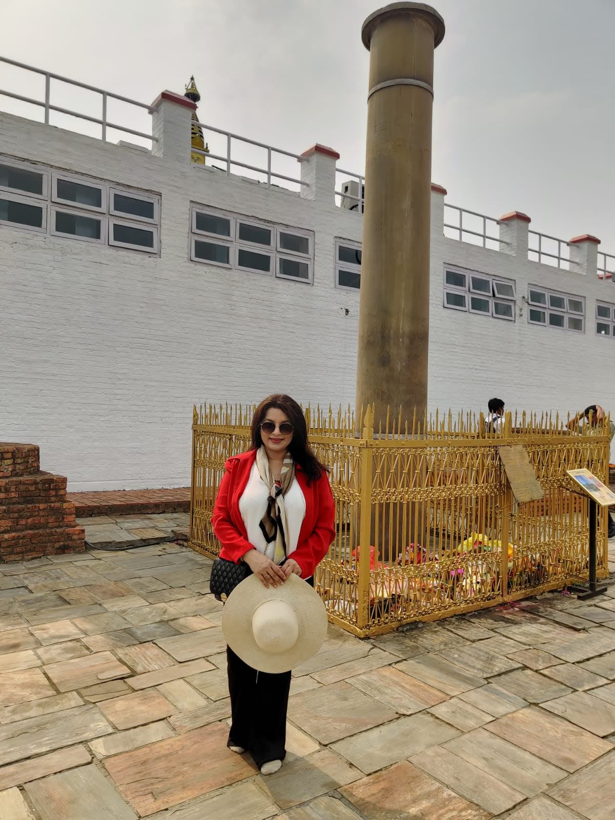 Monolithic sandstone Ashoka Pillar enclosed by a golden protective railing beside the Maya Devi Temple in Lumbini