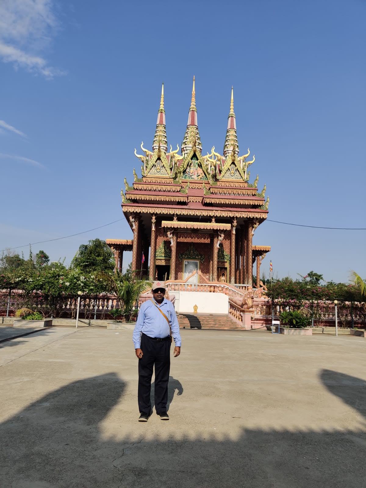 Three soaring golden Khmer prang spires and carved entrance portico of the Cambodian Monastery in Lumbini