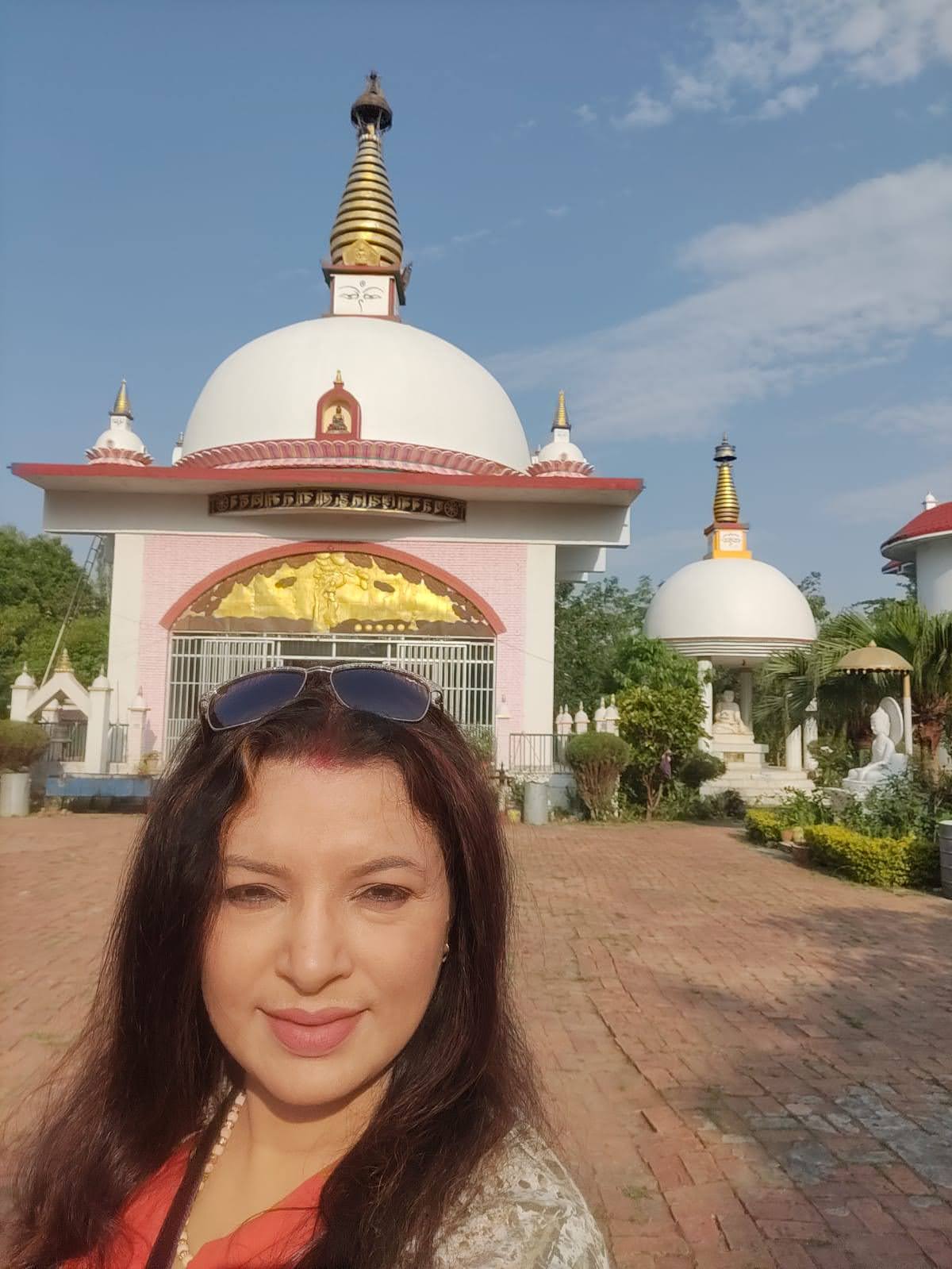International Gautami Nuns Temple with white domed pavilions, golden spires, and manicured green gardens in Lumbini