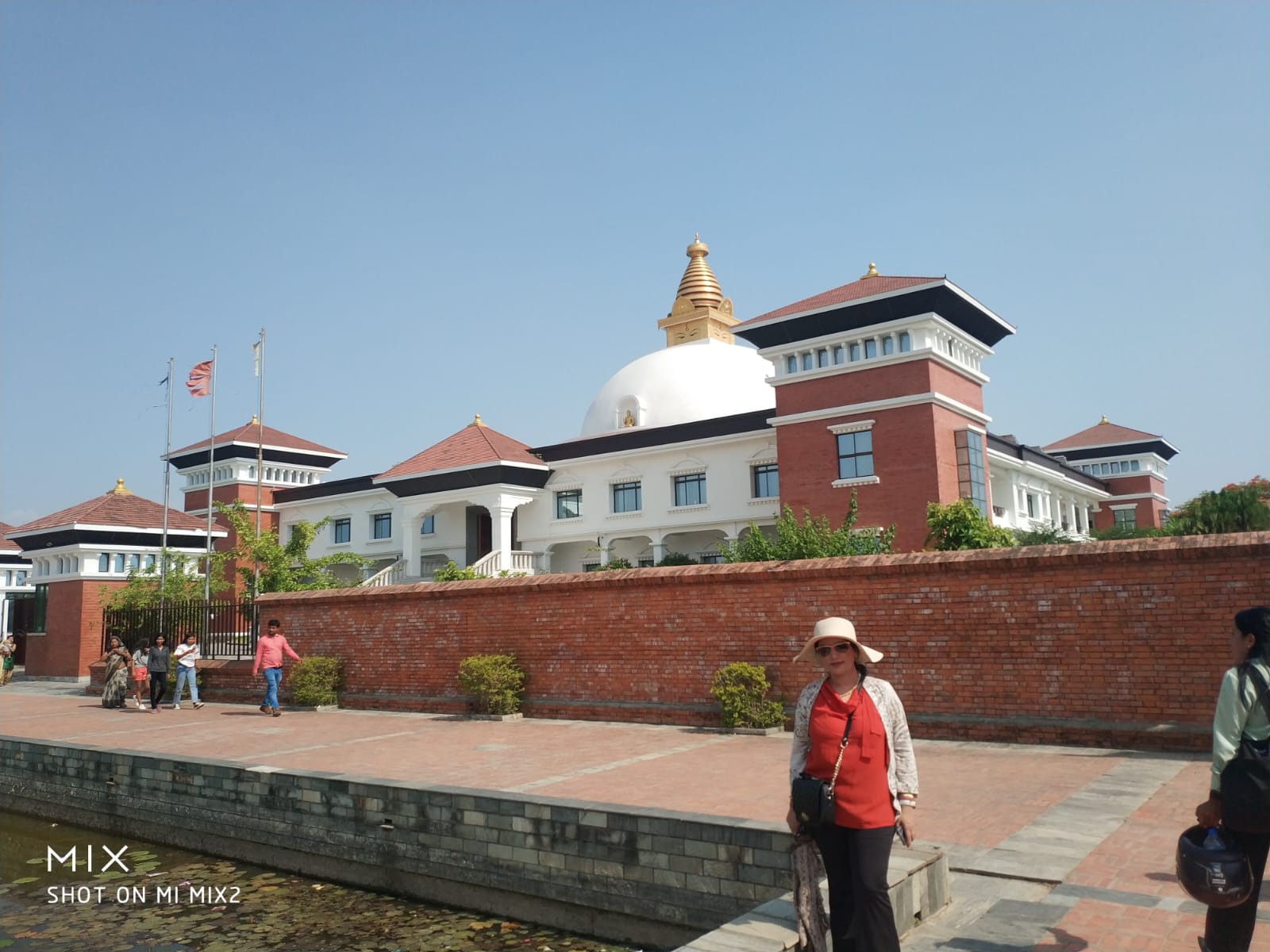 Lush green tree-lined central canal pathway running through the International Monastic Zone in Lumbini