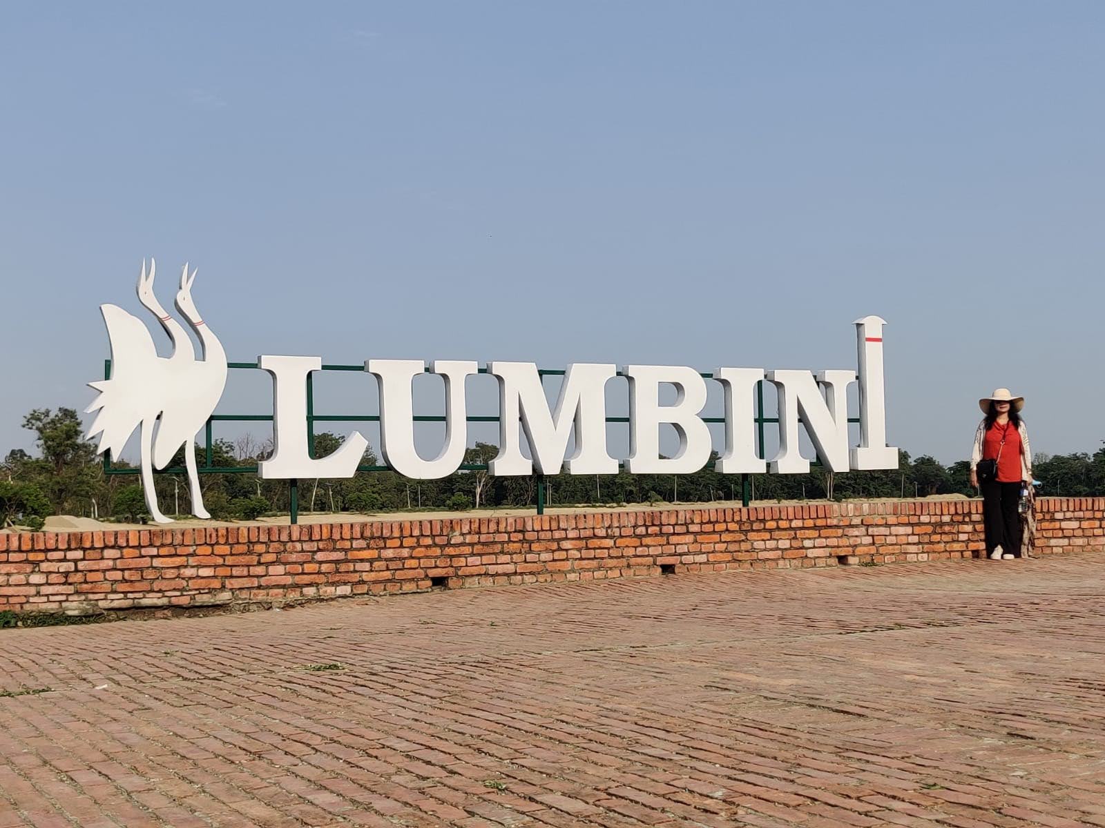Monumental white LUMBINI letter installation and Sarus crane sculptures on the brick plaza