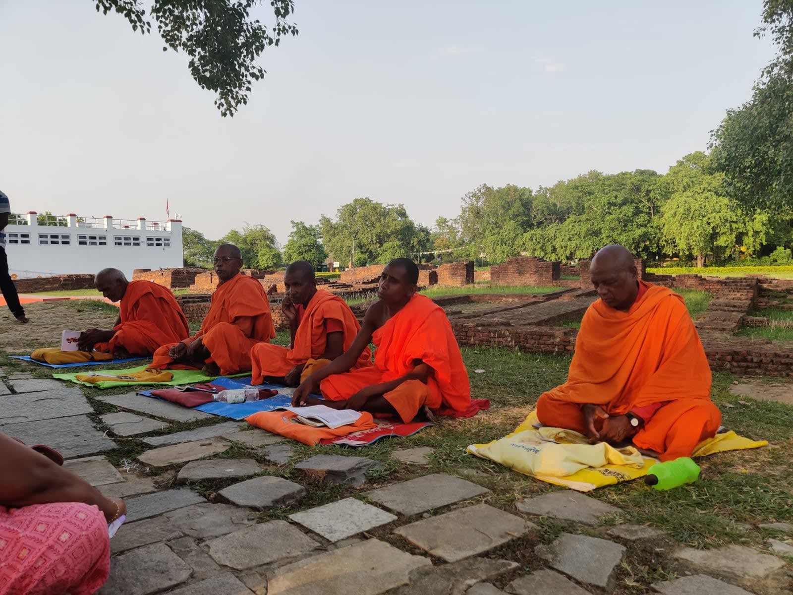 Pilgrims and Buddhist monks gathered in serene silent meditation within Lumbini Sacred Garden