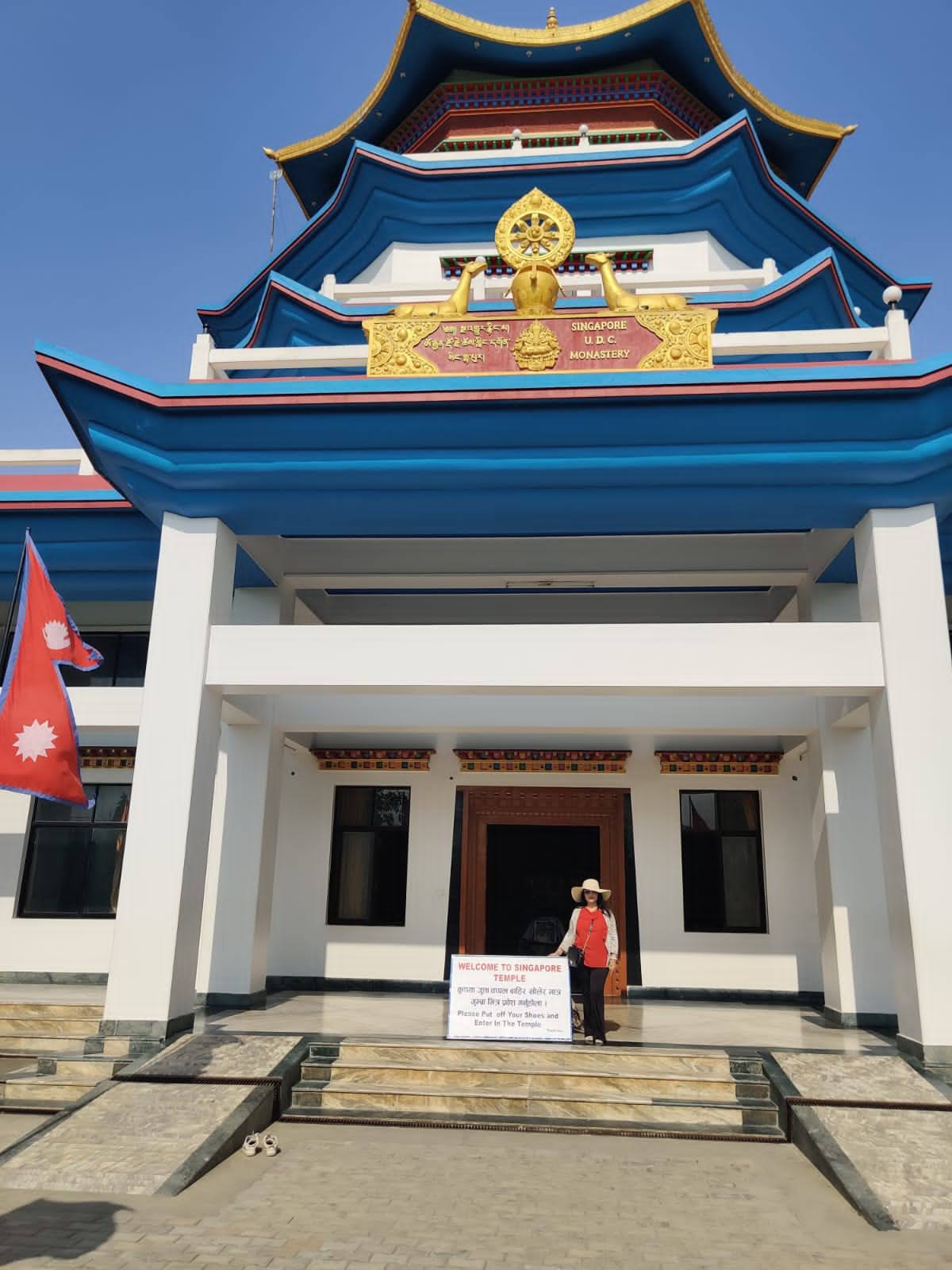 Traveler standing before the entrance of Singapore U.D.C. Monastery in Lumbini