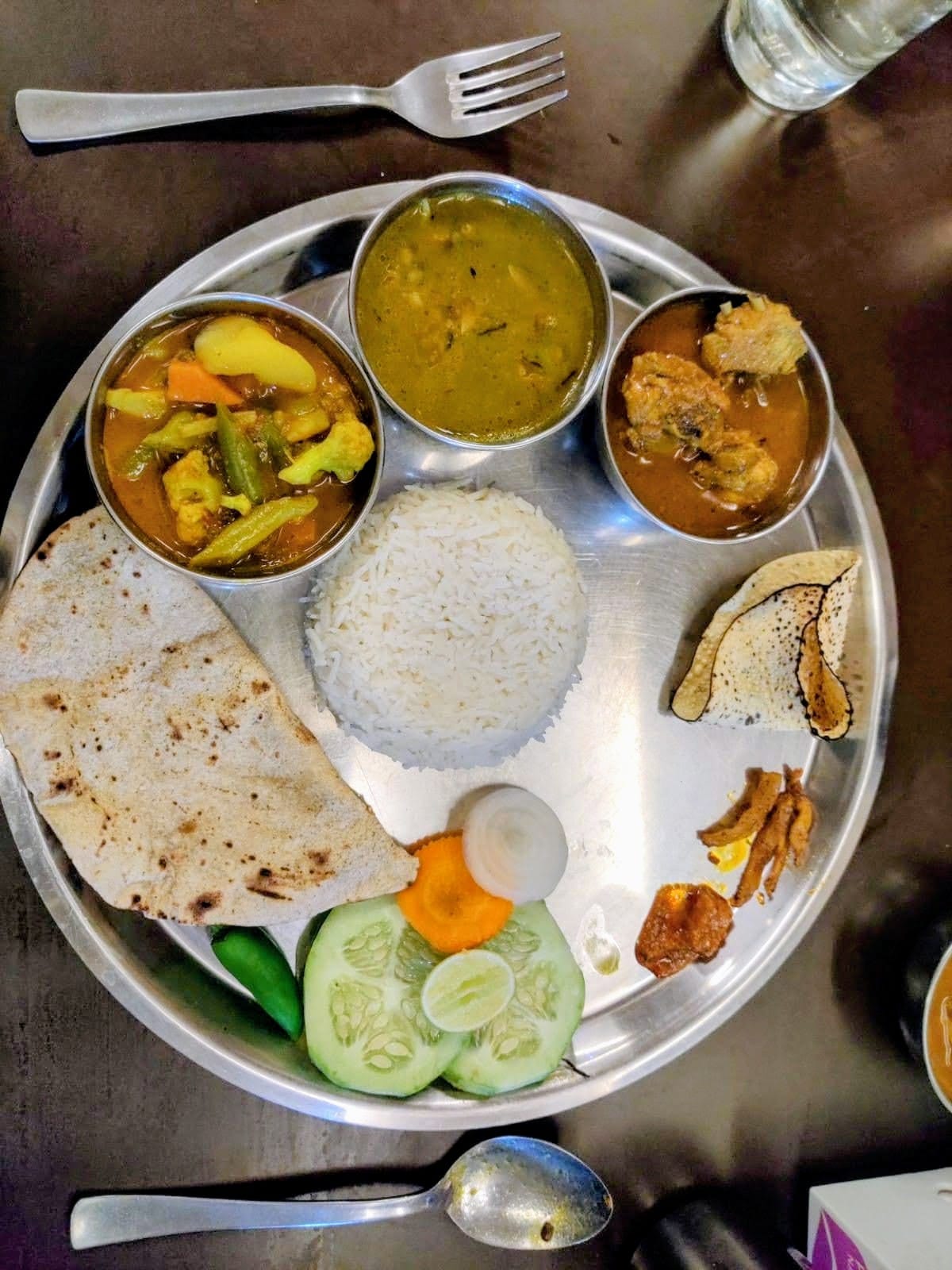 Traditional Nepali Thali platter with Dal, Bhat, Tarkari, Masu, Roti, Papad, and Achar