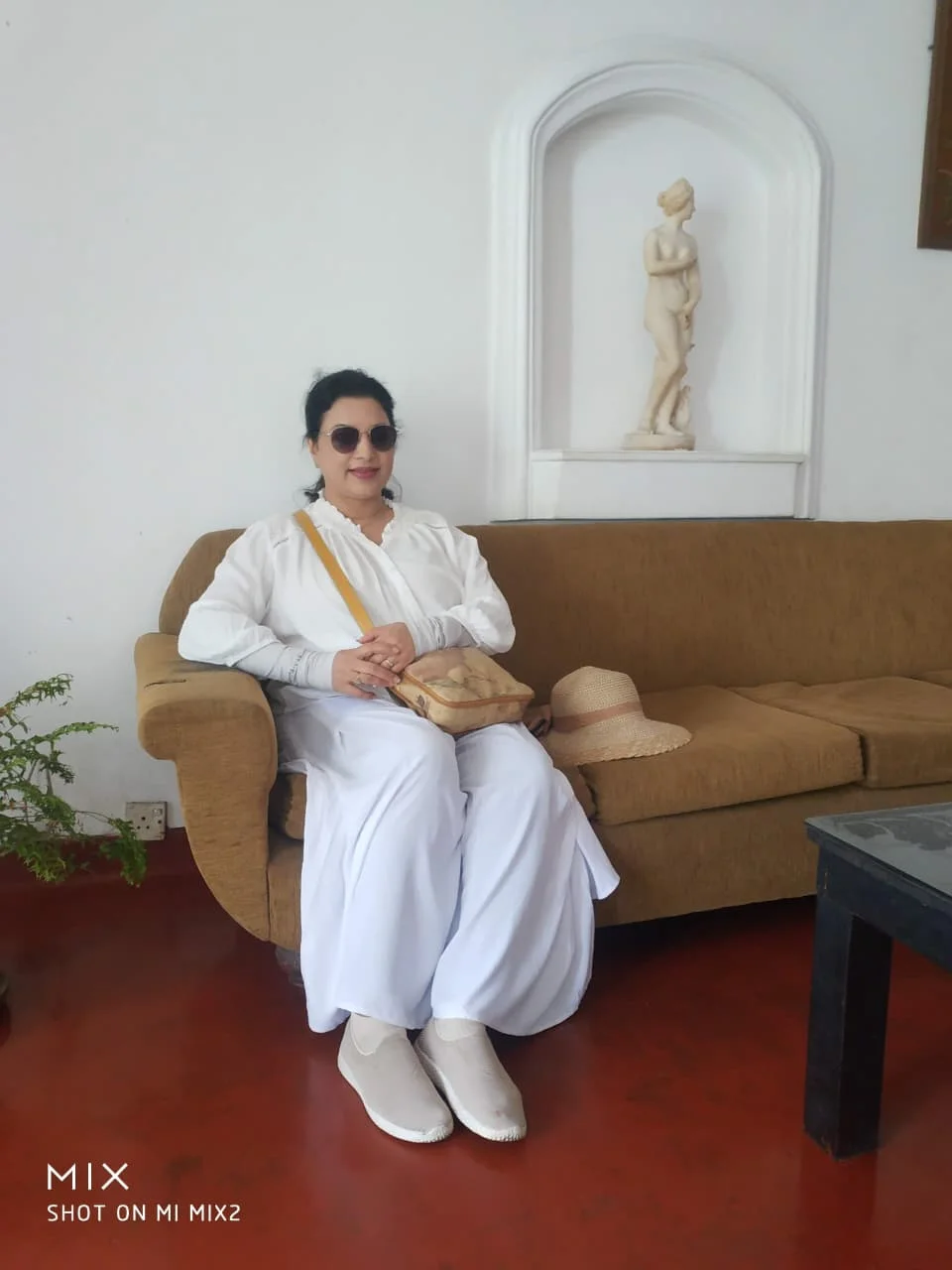 Traveler dressed in pure white observance garments seated in lounge before attending the sacred Buddhist festival