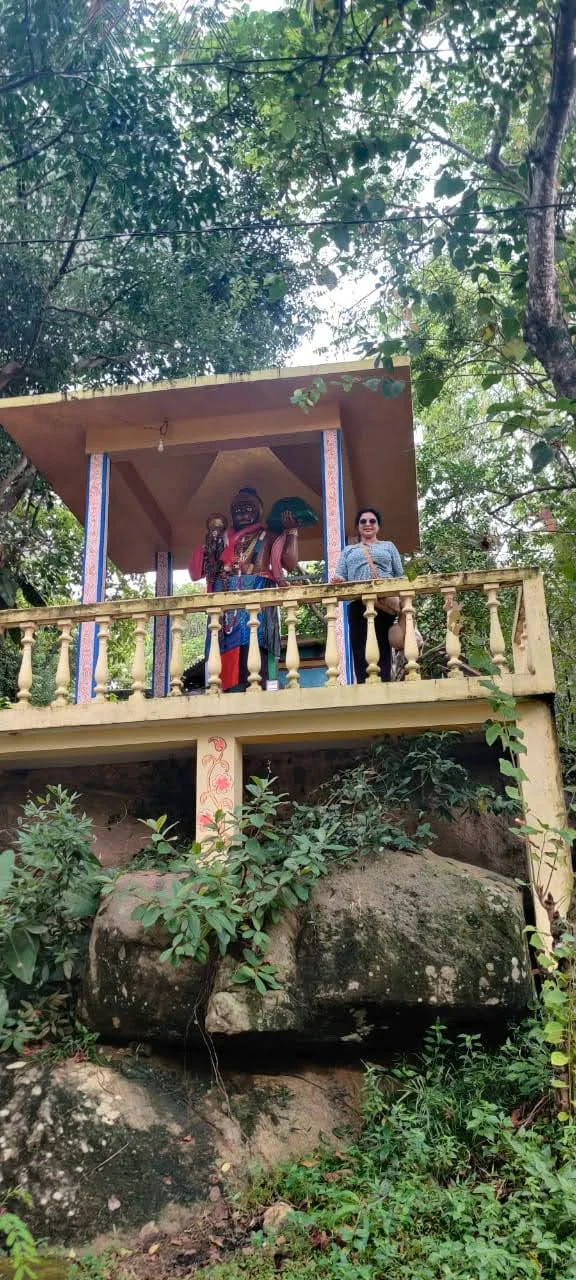 Traveler on the upper viewing terrace of the Rumassala hill shrine surrounded by tropical forest canopy