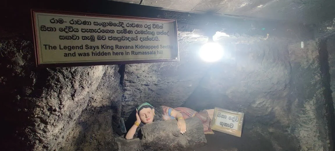 The cave interior at Rumassala with illuminated plaque stating The Legend Says King Ravana Kidnapped Seetha and was hidden here in Rumassala hill above a sculpted figure of Sita