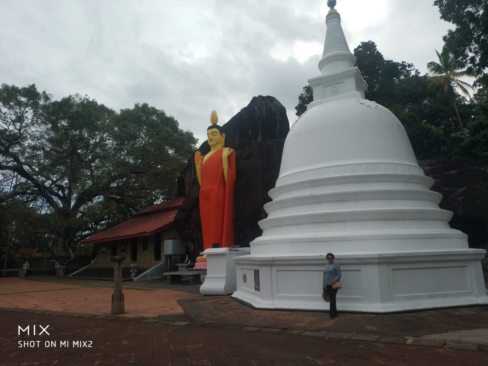 Towering seated Buddha statue of Weherahena rising against the tropical sky in Matara