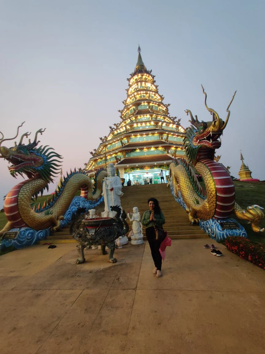 Wanderer at the dragon-flanked entrance stairway of the 9-tier pagoda at Wat Huay Pla Kang
