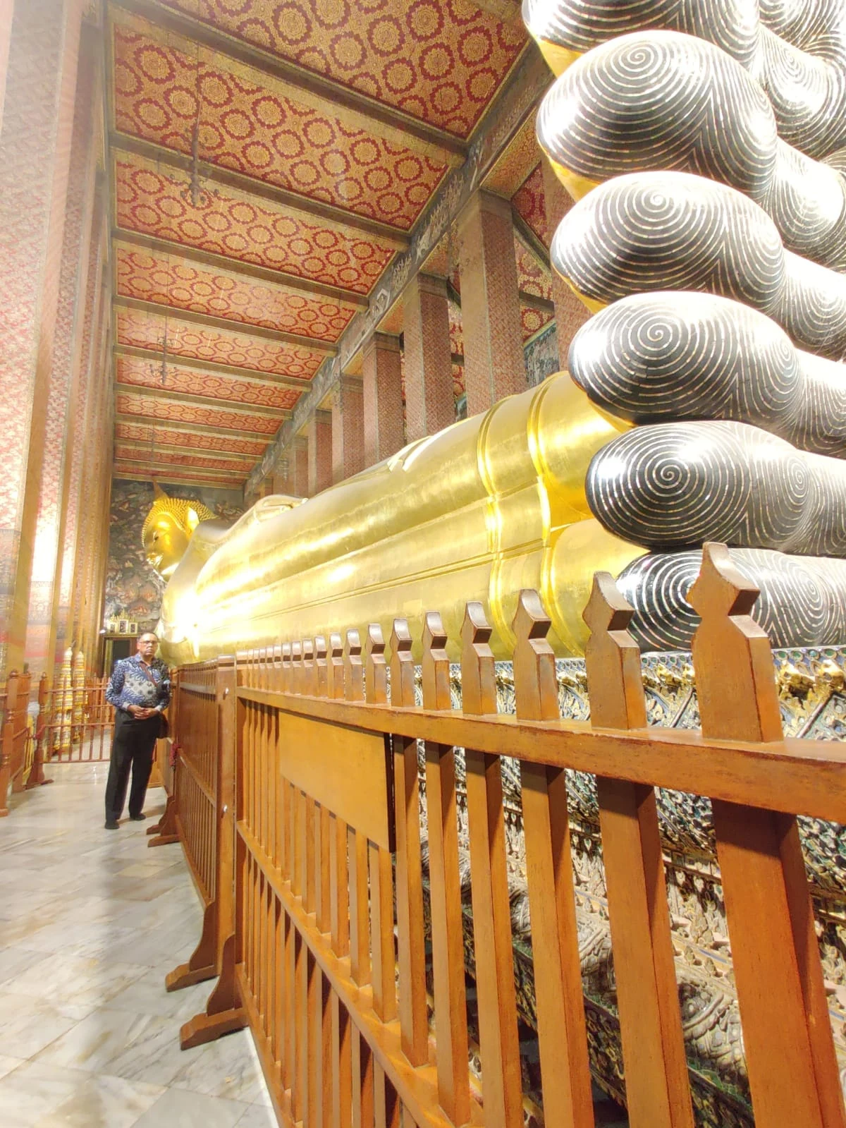Wanderer viewing the 46-metre gold leaf Reclining Buddha at Wat Pho