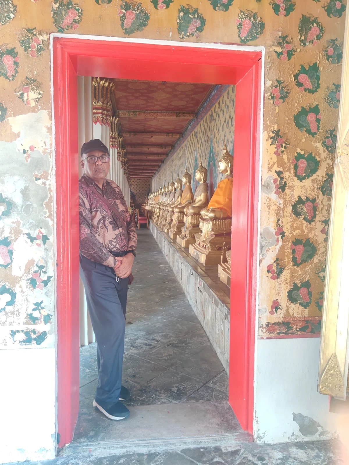 Serene cloisters of Wat Pho lined with gilded Buddha statues from Ayutthaya and Sukhothai