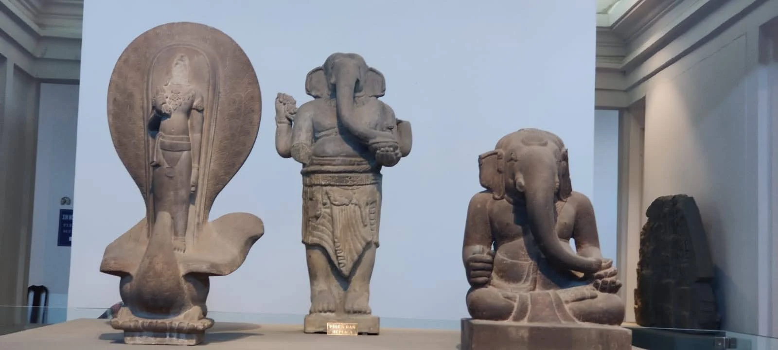 Sandstone sculptures of standing Shiva, standing Ganesha with halo, and seated Ganesha in Da Nang