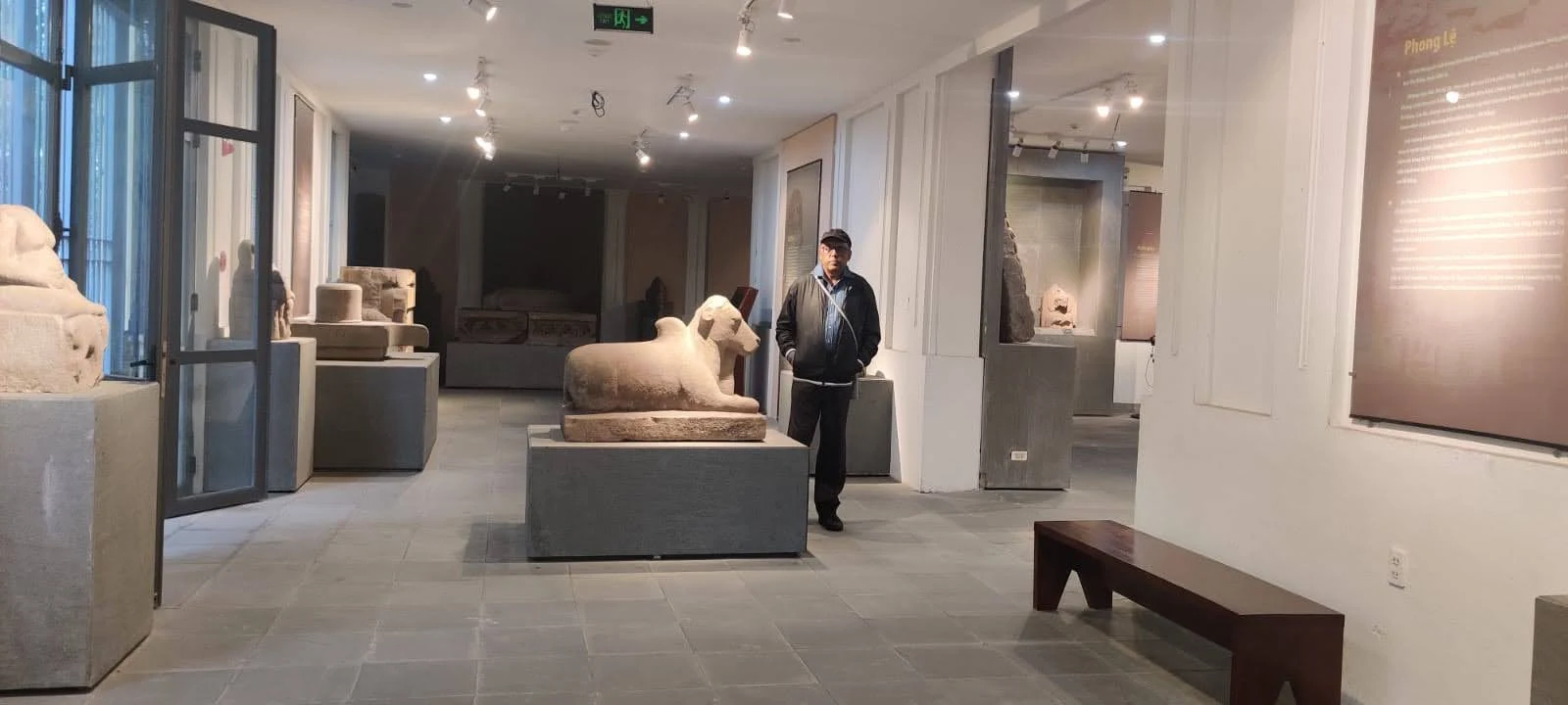 A quiet corridor of the Cham Museum lined with ancient stone sculptures and sacred Nandi