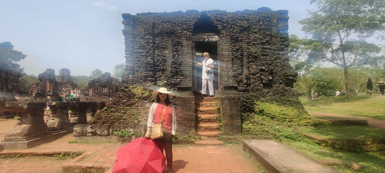Travelers at the entrance of the brick temple towers at My Son