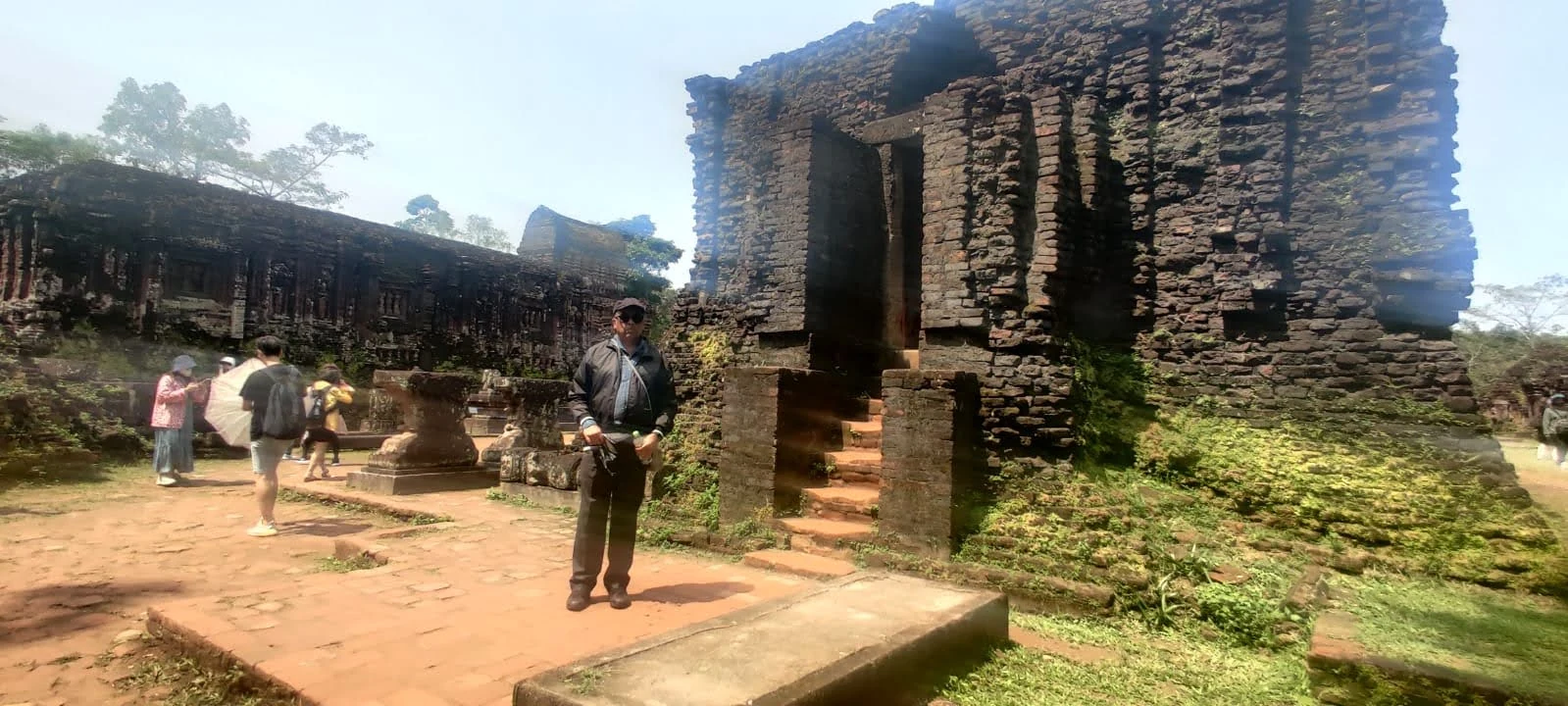 Sunlit brick courtyard and staircase leading into the temple ruins