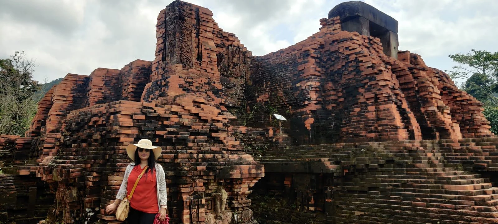 Collapsed red brick temple ruin bearing scars from Vietnam War bombing