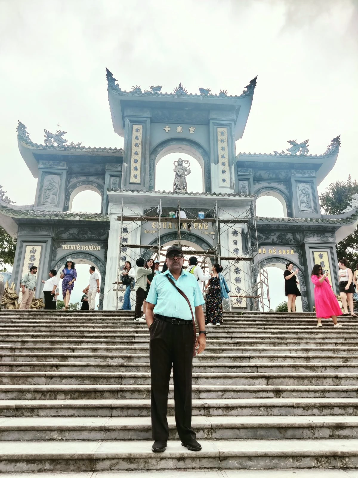 Male traveler standing on the grand staircase before the triple gate of Chua Linh Ung on Son Tra Peninsula