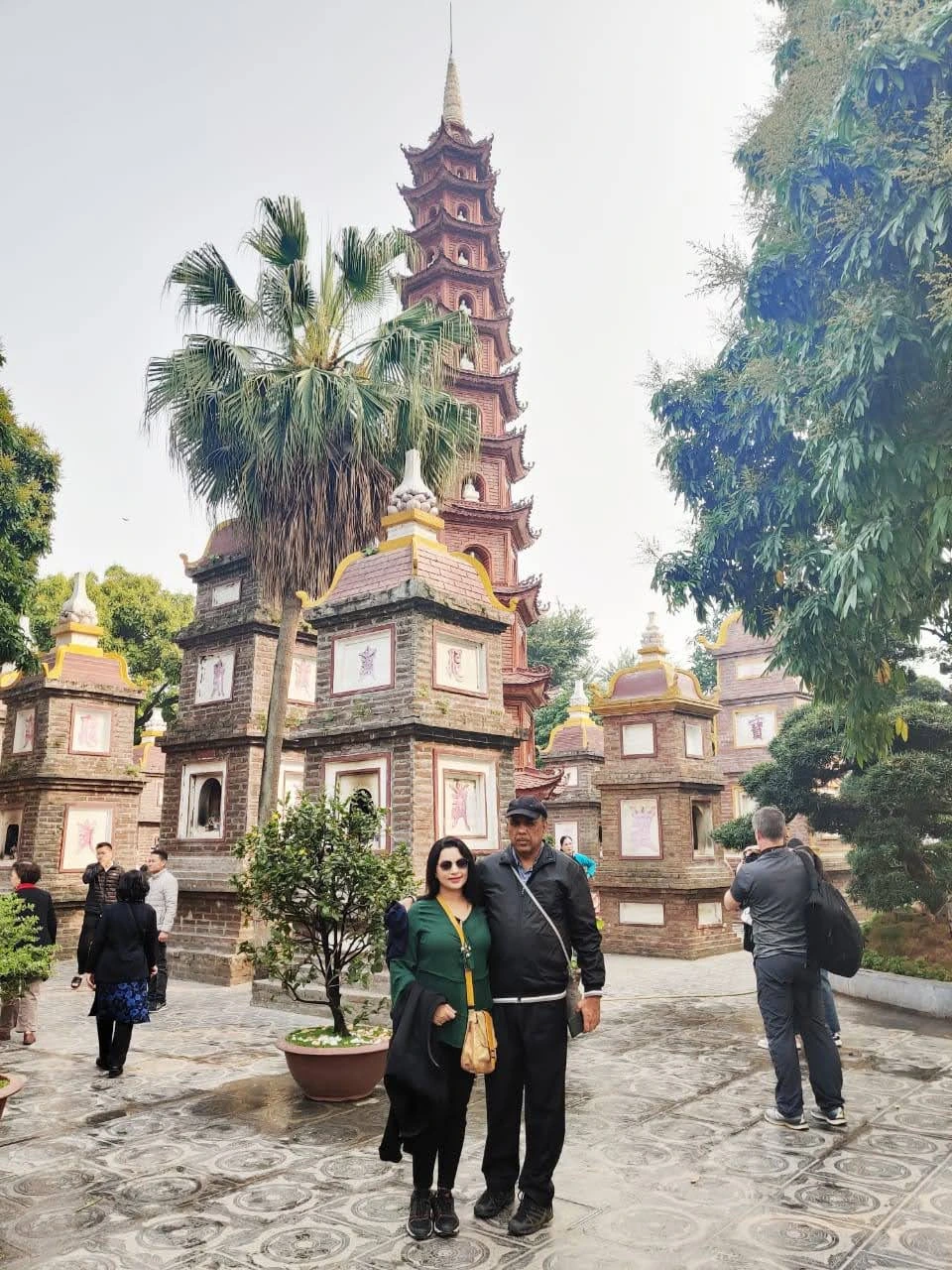Couple portrait in the stupa garden of Tran Quoc Pagoda in Hanoi surrounded by brick ancestral towers