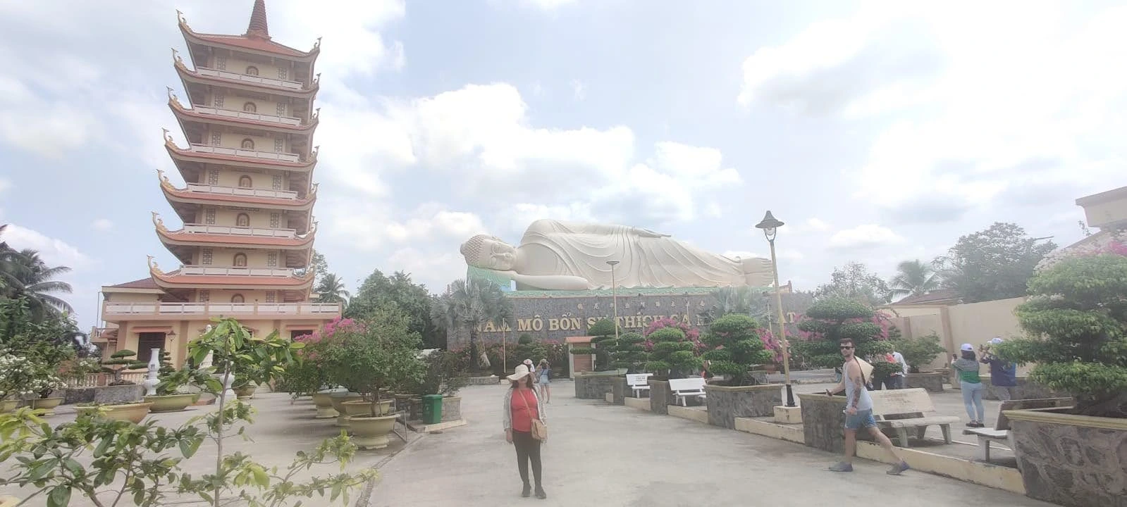 Courtyard view of Vinh Trang Pagoda showing the seven-tier pagoda tower and colossal Reclining Buddha