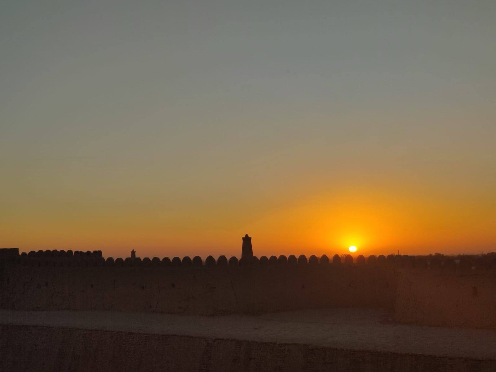 Breathtaking sunset view over the clay buildings and towering minarets of Khiva, Uzbekistan